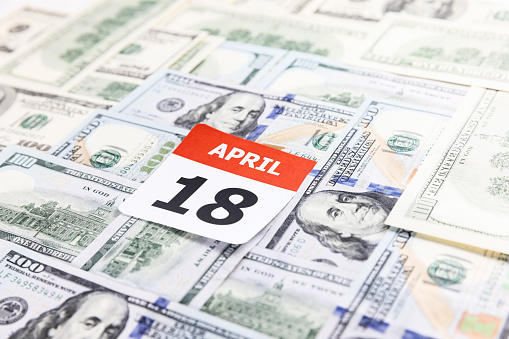 Calendar date 18 April 2022 - US tax day - on the US dollar currency background