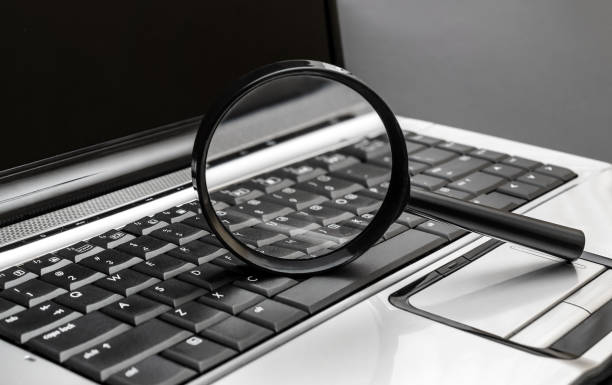 istock Magnifying glass on the laptop keyboard. 1306708576