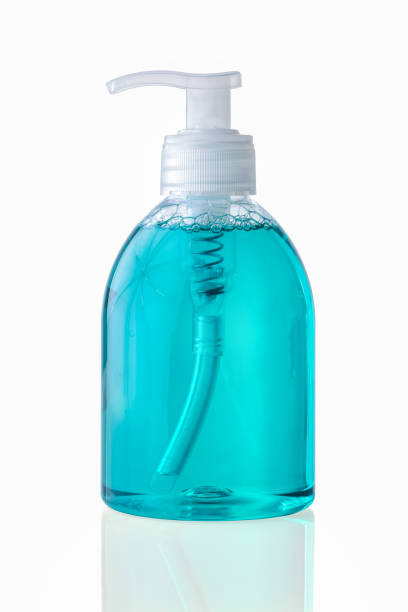 istock Hand disinfection in transparent plastic bottle pump with blue liquid isolated on white background 1306711430
