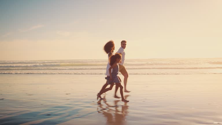 4k video footage of a couple spending the day at the beach with their daughter