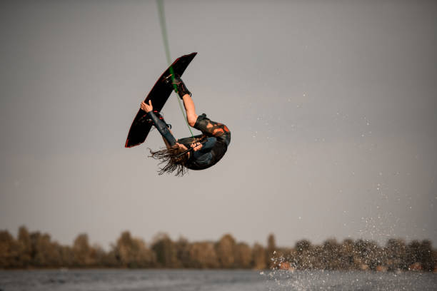 istock energetic guy jumps high and does somersault on wakeboard over the water 1306713778