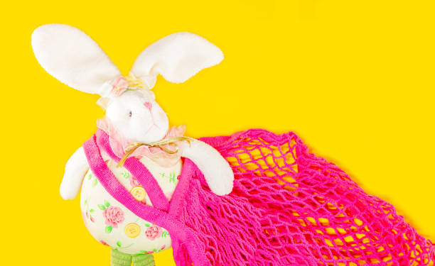 istock Easter bunny and a reusable shopping bag. Mesh String bag on yellow background. Zero waste, Eco-friendly easter shopper and Ecology concept. 1306714464