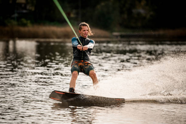istock young cheerful guy actively spends his leisure time and rides wakeboard. 1306714667