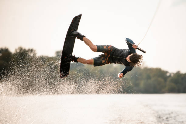 istock active male wakeboarder doing somersault in the air above water 1306714763