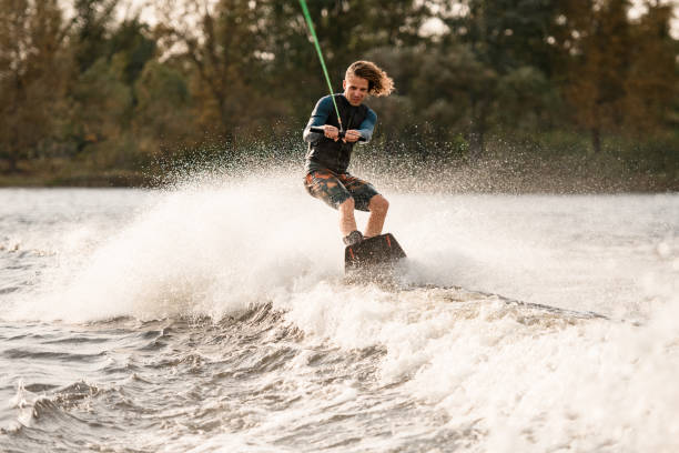 istock Beautiful view of man holding bright cable and balancing on wakeboard on wave. 1306714793