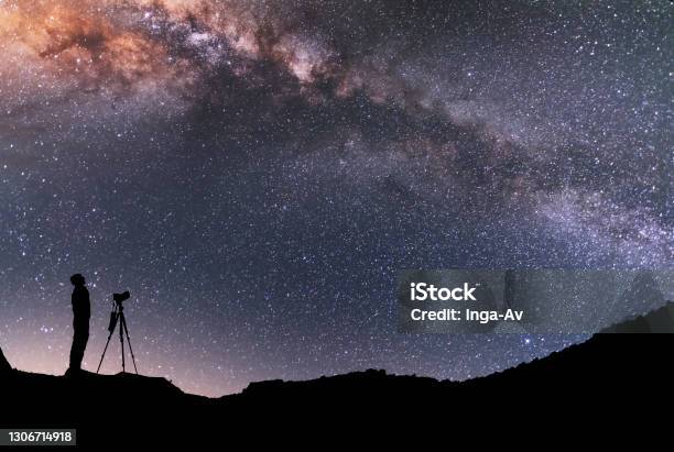 The Man Silhouette With Camera And Tripod Stands On The Hill And Looking At The Bright Milky Way Galaxy Beautiful Night Landscape Stock Photo - Download Image Now
