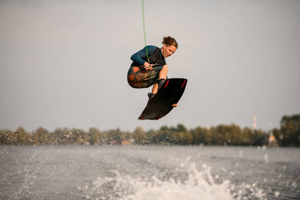 istock young energetic wakeboarder jumping high over river water 1306714966