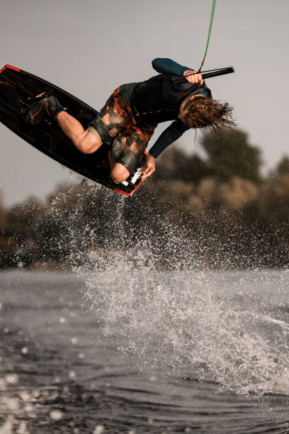 istock view of attractive man doing wakeboard flip while holding rope with his hand 1306715779