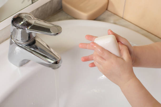 istock Child washing hands with soap under the tap 1306715800
