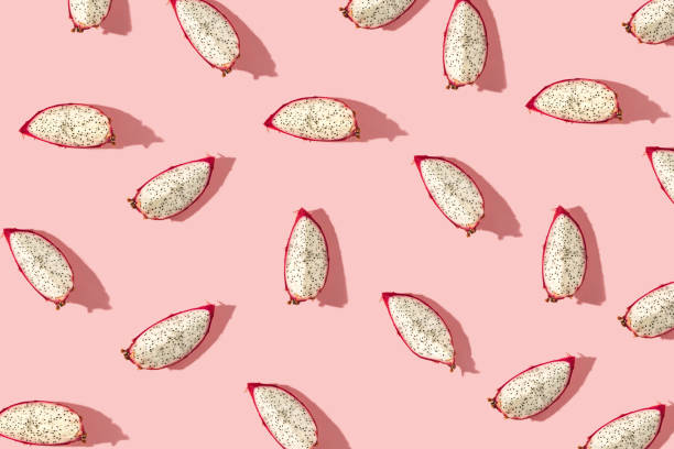 istock Pattern created from fresh exotic dragon fruit slices on pastel pink background. Top view. 1306718248