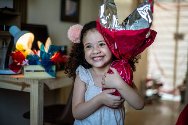 istock Cute little child. Girl eating chocolate easter egg 1306718350