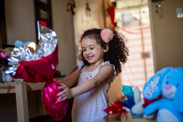 istock Cute little child. Girl eating chocolate easter egg 1306718482