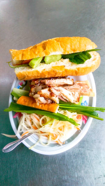 Baguette and grilled pork belly in Cambodia gravy style with Khmer pickles make from white radish and carrots, This food called : Nom pang, Num pang