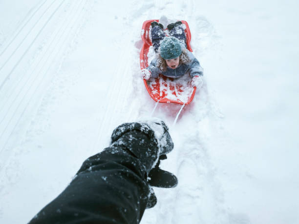 istock First Person View of Parent Pulling Child on Snow Sled 1306728077