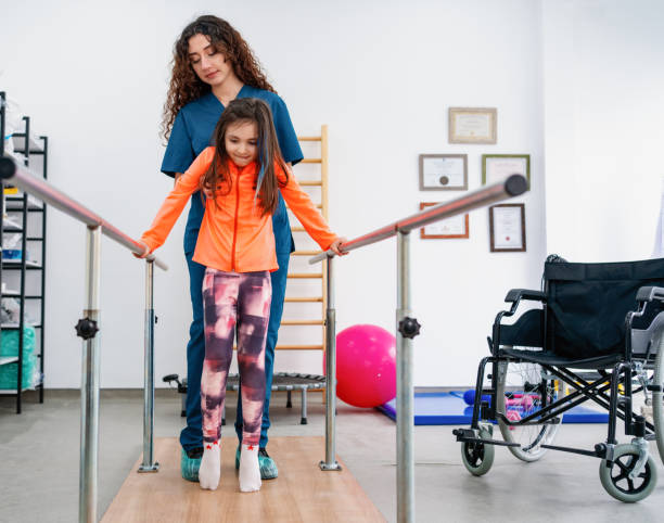 Young patient doing physiotherapy at a clinic with help of a therapist young patient doing physiotherapy at a clinic with help of a therapist after suffering an injury - rehabilitation concepts girl patient stock pictures, royalty-free photos & images