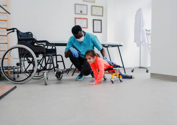istock Physical therapist helping girl to crawling with wheeled frame 1306728110