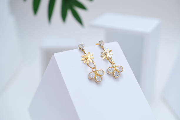 boucles d’oreilles d’or sur la boîte en bois blanche, image abstraite des bijoux d’or - gold earrings photos et images de collection