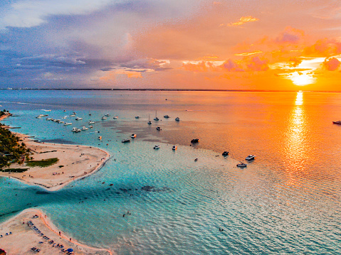 Aerial view during sunset time at Isla Mujeres in Cancun - Mexico.\nIncredible transparent and blue waters and orange sky