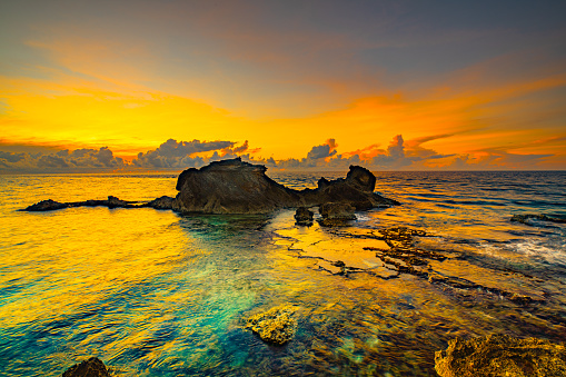 sunset time at Isla Mujeres in Cancun - Mexico.\nIncredible transparent and blue waters and orange sky. South point.