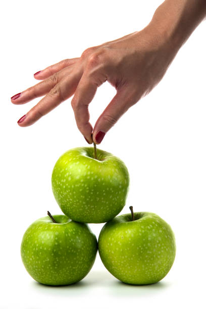 istock Woman hand holding green apples on white background 1306742161