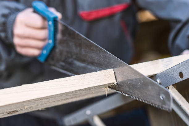istock Carpenter cutting a board with a hand saw 1306744262