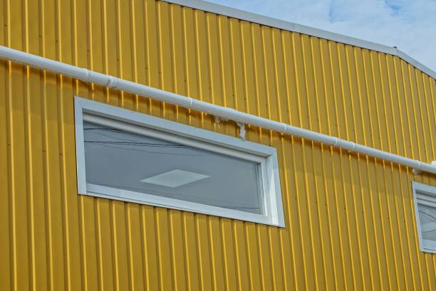 istock one small white rectangular window on a yellow metal wall of a building 1306749636