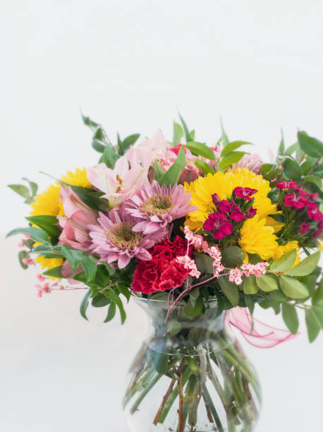 istock Colorful spring flowers bouquet in vase on white background 1306756552
