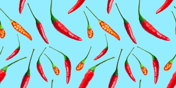 istock Seamless pattern of red hot chilli peppers isolated on blue background. Top view 1306759447
