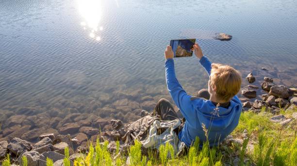 istock Young man relaxes by lakeshore in the morning 1306760292