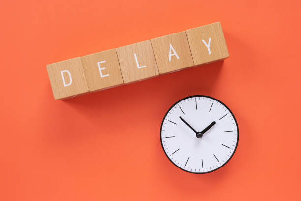 ritardo; cinque blocchi di legno con testo di concetto "delay" e un orologio semplice. - delayed foto e immagini stock