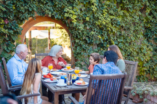 istock Seniors Smiling and Conversing with Grandson at Breakfast 1306762512