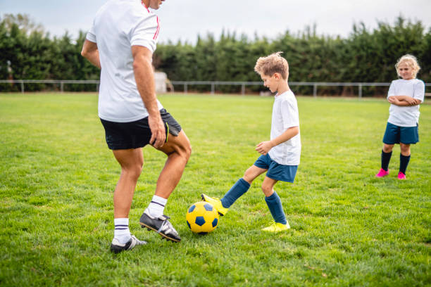 istock Pre-Adolescent Footballer Practicing Ball Control with Coach 1306763742