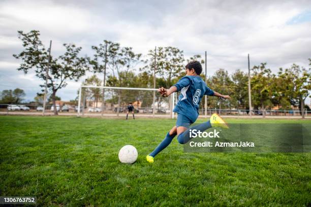 Athletic Mixed Race Boy Footballer Approaching Ball For Kick Stock Photo - Download Image Now