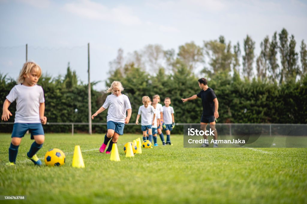 Vorjugendliche Fußballer dribbeln um Pylonen - Lizenzfrei Kind Stock-Foto