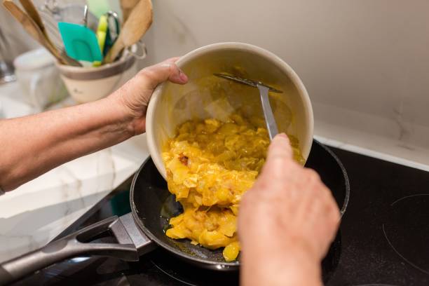 Woman cooking a potato omelet Woman cooking a potato omelet tortilla de patatas stock pictures, royalty-free photos & images