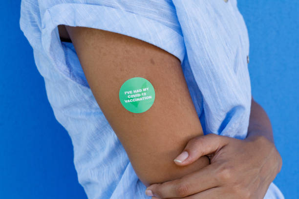Close Up Of Arm Of African Woman With COVID-19 Vaccine Sticker African Woman Proudly Displaying Her COVID-19 Vaccine Sticker - 'I've Had My Covid-19 Vaccination' herd immunity photos stock pictures, royalty-free photos & images