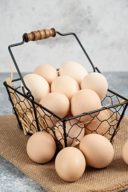 istock Metal basket of raw chicken eggs on marble surface 1306777987