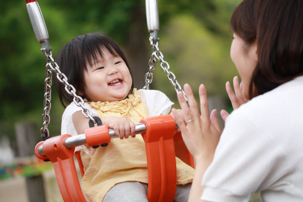 istock Parents and children playing on a swing 1306779834