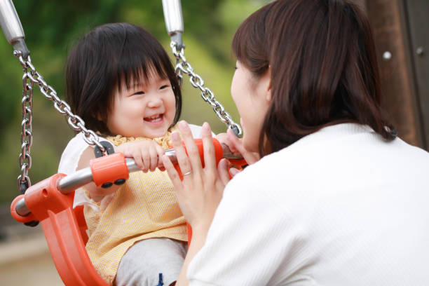 istock Parents and children playing on a swing 1306780574