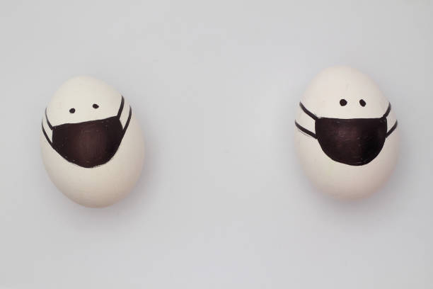 istock Easter eggs with Corona virus COVID19 protection concepts. DIY Do It Yourself easter eggs wearing mask for Easter holidays decoration on white background Selective focus with copy space. 1306781294