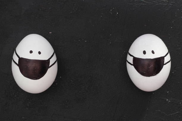 istock Easter eggs with Corona virus COVID19 protection concepts. DIY Do It Yourself easter eggs wearing mask for Easter holidays decoration on black background Selective focus with copy space. 1306781553