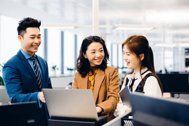 istock Asian young business people in discussion in an open working environment. 1306784878