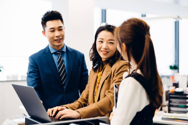 istock Asian young business people in discussion in an open working environment. 1306785129