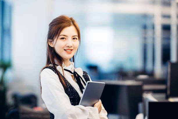 istock Professional Asian businesswoman with notepad in office. 1306785670