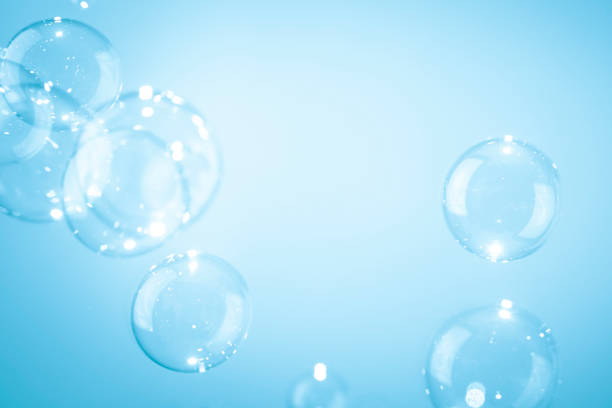 istock Beautiful shiny transparent soap bubbles floating on a blue background. 1306788990