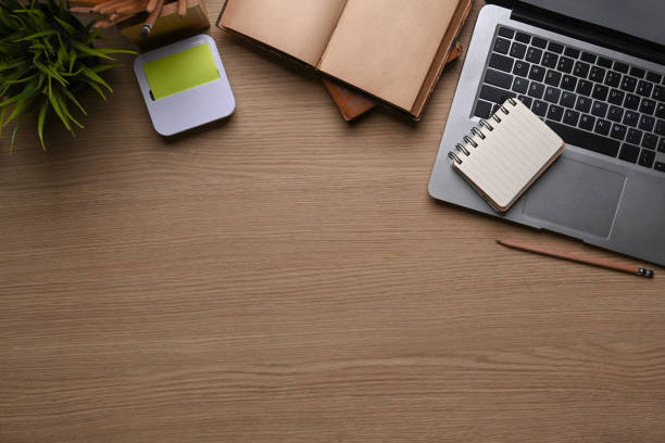 istock Above view of comfortable workplace with laptop computer, notebook, plant, sticky note and copy space. on wooden background. 1306789909
