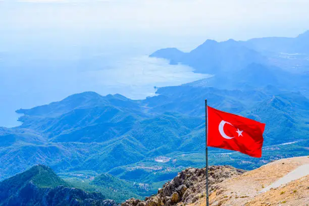 Photo of View on Mediterranean sea and hills from the summit of Tahtali mountain. Turkish flag on foreground