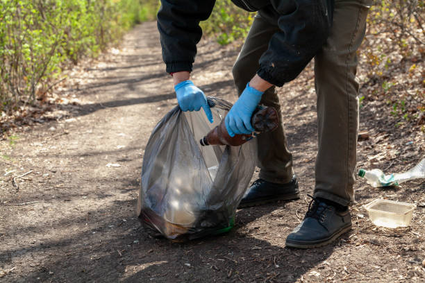 istock Man in gloves collects plastic trash in forest 1306797397