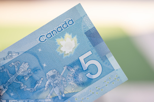 Cierre del billete azul canadiense de cinco (5) dólares con fondo desenfocado borroso. Macrofotografía. photo