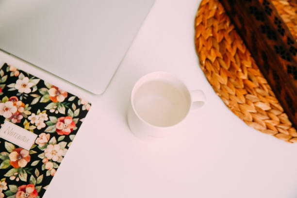 istock Home office workspace with laptop, candle holder, mug, notebook, grass bouquet. Light aesthetic hygge space. Freelance work, business workplace. 1306799580